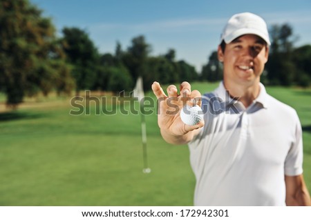 Golf man holding hole in one ball