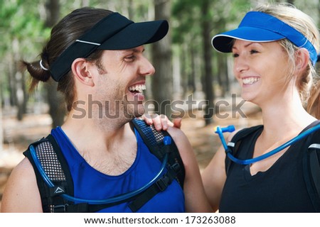 Happy active couple laughing together for trail runner portrait