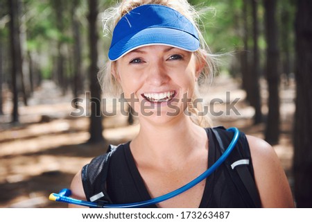 Happy fit healthy woman smiling while trail running