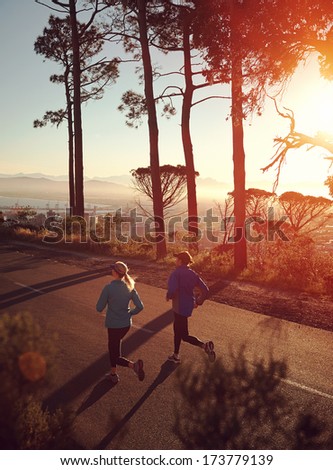 Running at sunrise couple exercising for marathon and workout fitness