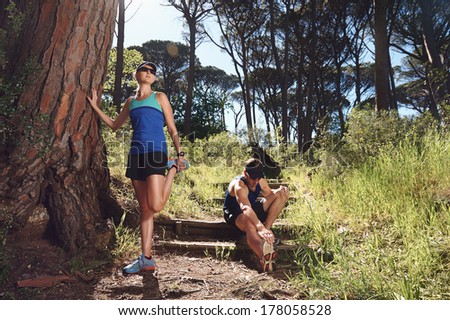 stretching runners on trail before morning run