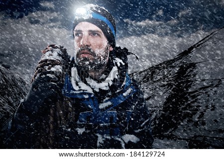 Adventure mountain man in snow expedition with climbing gear and determination