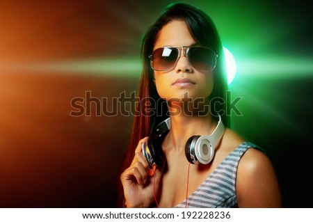 DJ woman portrait with headphones and nightclub lights