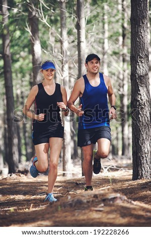 Fit marathon couple trail running together for sport and healthy living