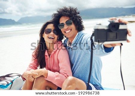 couple taking selfie self portrait at the beach with retro hipster camera couple taking selfie self portrait at the beach with retro hipster camera