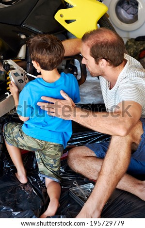 father and son repair old motorcycle together