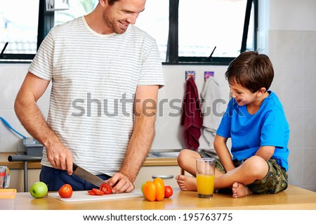 happy dad and son making healthy food together in kitchen