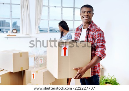 young black african couple moving boxes into new home together making a successful life