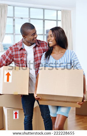 young black african couple moving boxes into new home together making a successful life