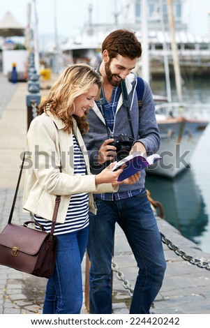 tourist couple with guide book on vacation