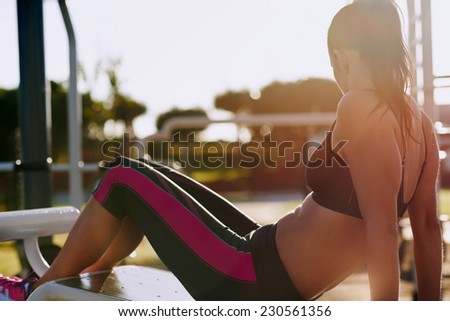 fitness woman doing situps in outdoor gym woking out strength training