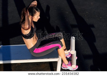 fitness woman doing sit ups in outdoor gym woking out strength training