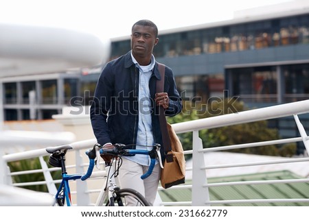 young trendy black african hipster man with bicycle walking in urban city on way commute to work
