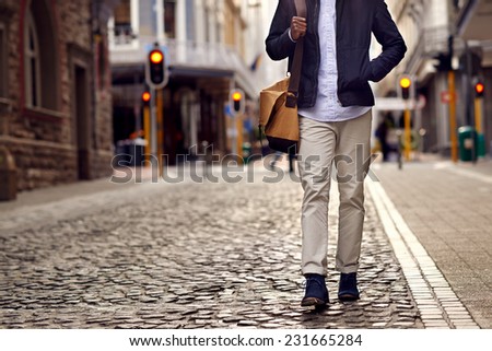 Young african man on vacation exploring european city cobblestone street