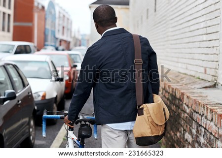 young trendy black african hipster man with bicycle walking in urban city on way commute to work