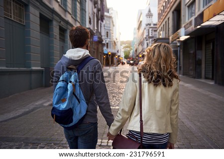 Happy young tourist couple walking street on vacation together