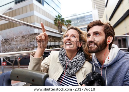 tourist couple on open top bus tour guide around the city in vacation