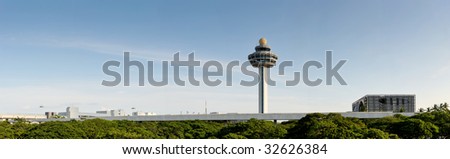 The control tower of Changi Airport in Singapore. this panoramic shows off the garden city\'s green trees, blue skies and cleanliness. the air traffic control tower sticks out into the sky.