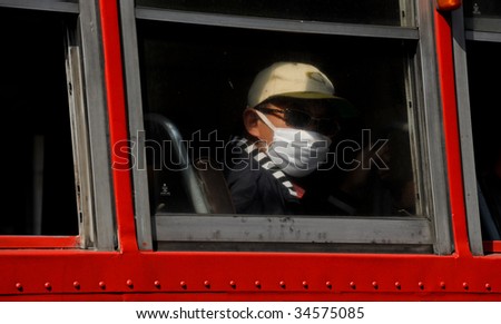BANGKOK, THAILAND - CIRCA DECEMBER 2008: A man covers his mouth with a mask to prevent the inhalation of air pollution in Bangkok, Thailand CIRCA DECEMBER 2008.