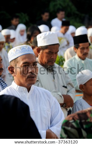 JAKARTA, INDONESIA - SEPTEMBER 20: A Muslim man prays with fellow Muslims outside a mosque in Jakarta on Hari Raya, the end of a month of fasting called Ramadan September 20, 2009 in Jakarta.