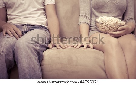 Young couple watch a movie and eat popcorn at home