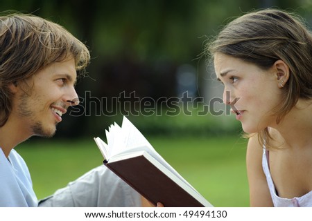 Attractive couple read together in the park