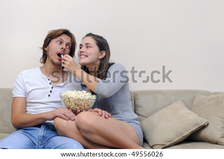 Couple watch a movie at home with popcorn