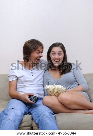 Couple watch a movie at home with popcorn