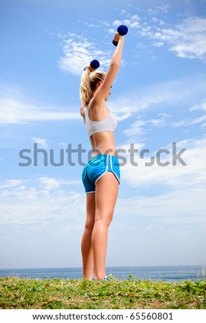 Young blond female works out with dumbells