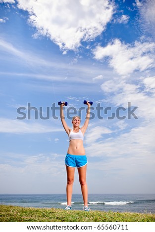 Young blond female works out with dumbells