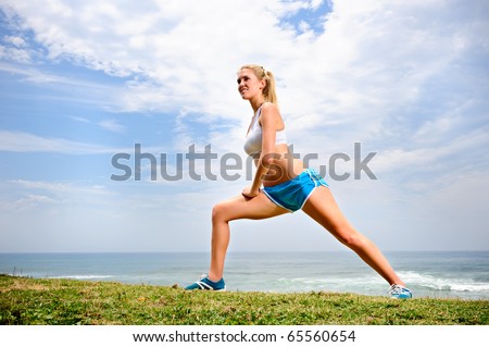 Young blond female stretches her leg