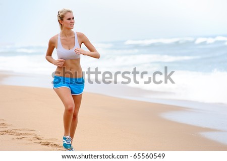 Young blond female runs along the beach