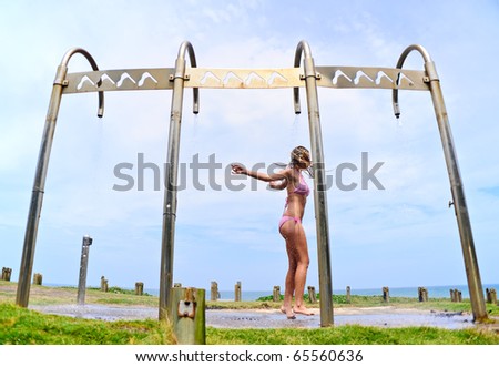 Dancing bikini babe in an outdoor shower on the beach