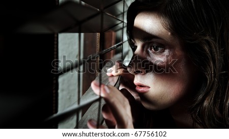 Fearful battered woman peeking through the blinds to see if her husband is home