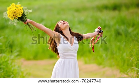 Carefree girl is happy in field with flowers