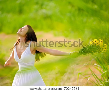 Carefree adorable girl with arms out in field. summer freedom andjoy concept.