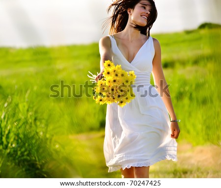 Candid skipping carefree adorable woman in field with flowers at summer sunset. Candid skipping carefree adorable woman in field with flowers at summer sunset.