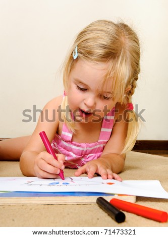 blonde girl drawing with crayons in school
