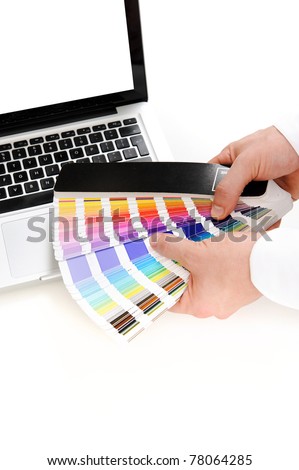 Tools of the trade of a graphic designer; a laptop computer and a spectrum of color swatches