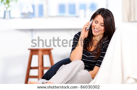 Attractive brunette chatting on the telephone at home