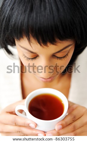 Attractive brunette enjoys her cup of tea before she goes to work