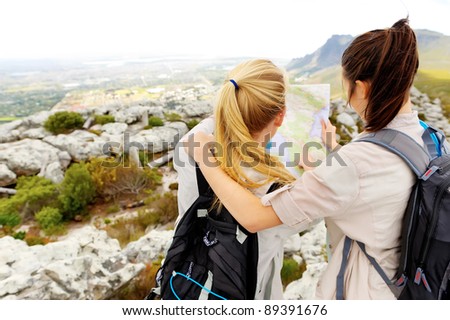 friends try to find their bearings on a map while hiking outdoors. leading a healthy lifestyle