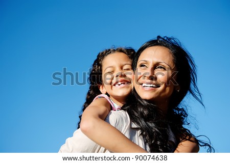 carefree vitality image of mother and daughter playing together outdoors