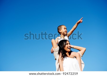 Mom and son happy and free outdoors in the blue sky. carefree cheerful concept