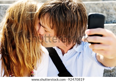 Image of couple kissing for cell phone picture