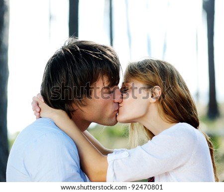 beautiful young couple kiss outdoors in the forest, true love and passion