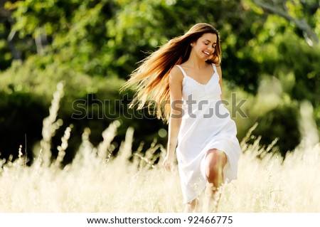 beautiful carefree woman skips and plays outside, cheerful and smiling