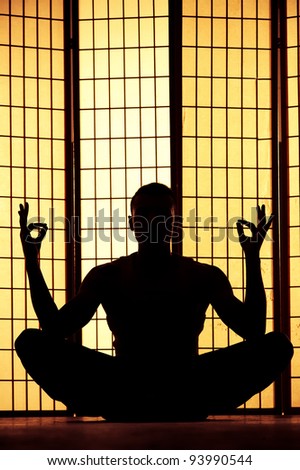Silhouette of a man meditating and finding a zen moment