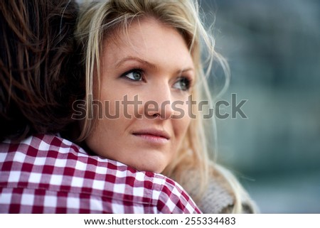 Nostalgic woman hugging her husband in the windy outdoors