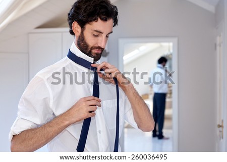 professional man getting ready morning routine shirt and tie at home